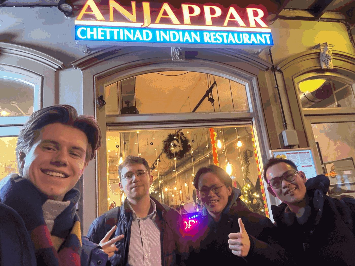 Empat sahabat KukuBima berpose di depan restoran pada malam hari