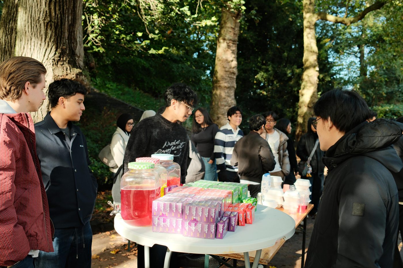 Para mahasiswa di stan KukuBima kami pada acara perkenalan PPI, dengan ketiga rasa di atas meja di samping dispenser minuman